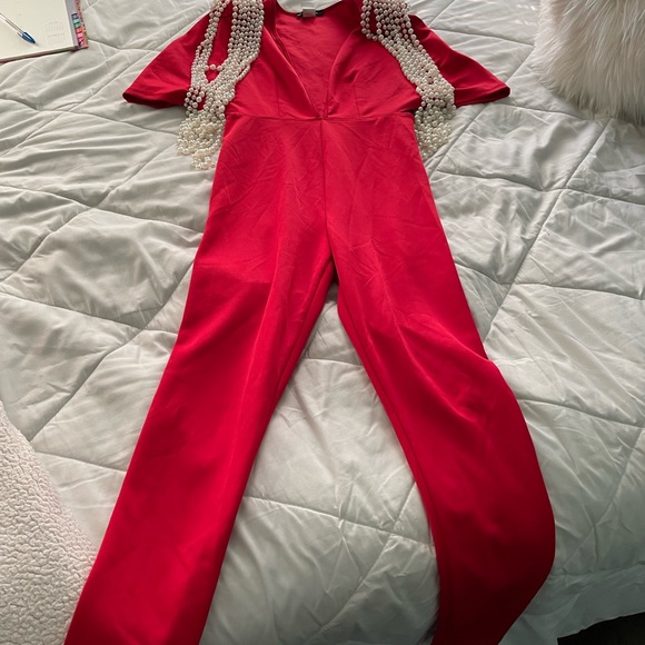 Vibrant Red Jumpersuit with structured pearl draped along shoulder pads. - Picture 5 of 5